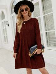 Cable knit A-line sweater dress in wine with crew neck and long sleeves.