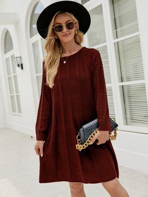 Cable knit A-line sweater dress in wine with crew neck and long sleeves.