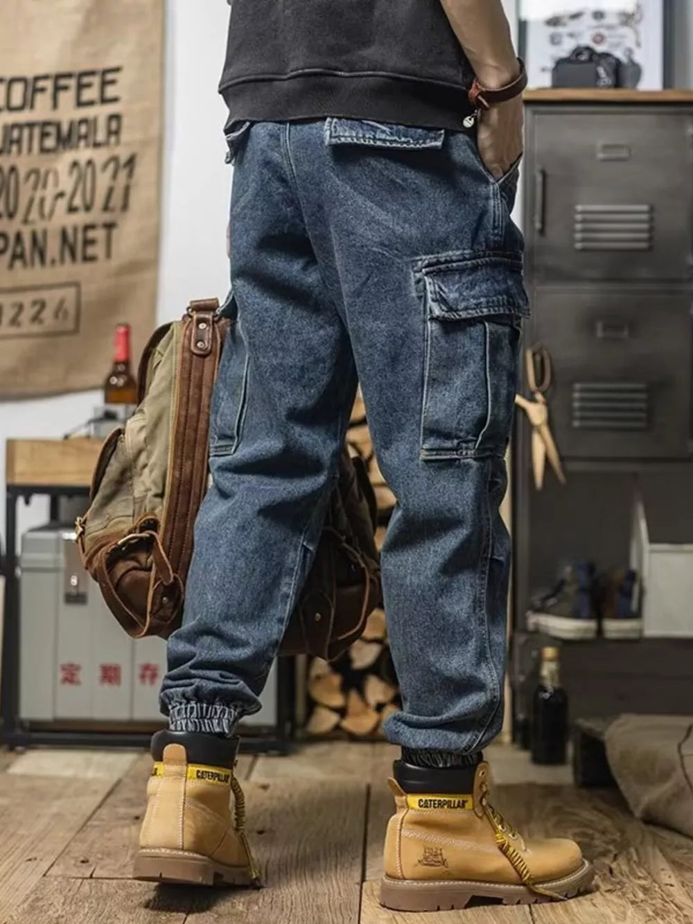 Men's vintage wash blue denim cargo jeans with multiple pockets and cuffed ankles.