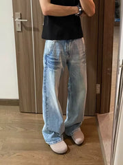 Men's light wash vintage wide-leg jeans with distressed details.