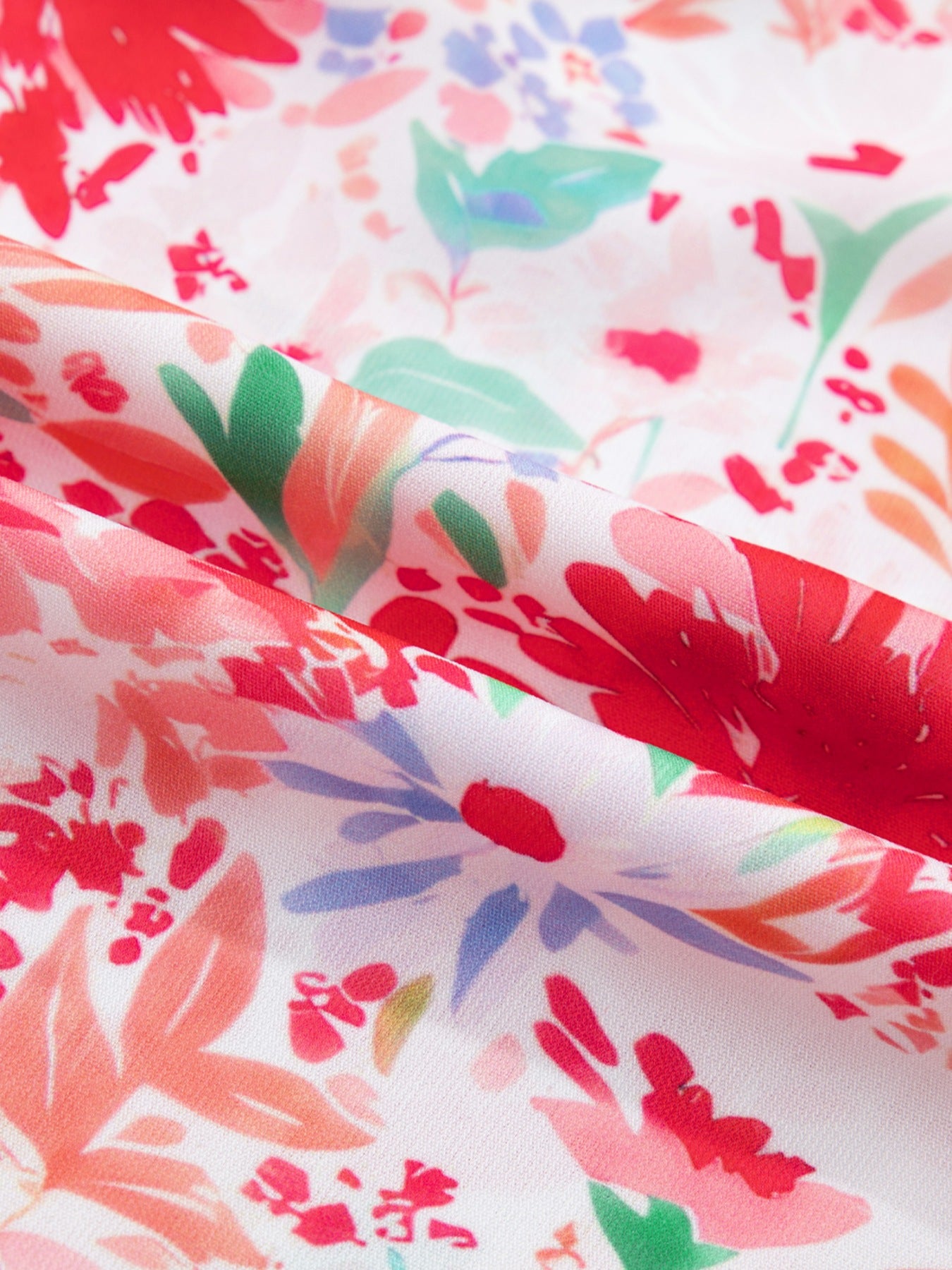 Floral print midi dress with tie shoulders in white with red, pink, and blue flowers.