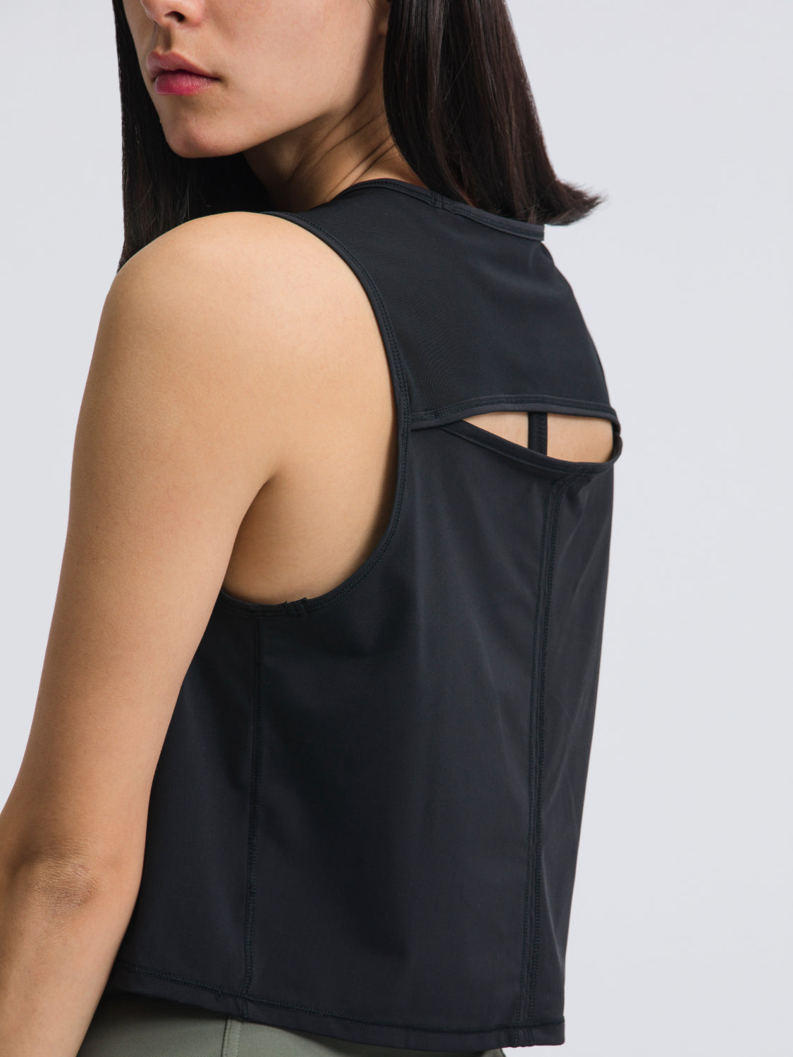 Black cropped active tank with mesh inset back detail and racerback strap.