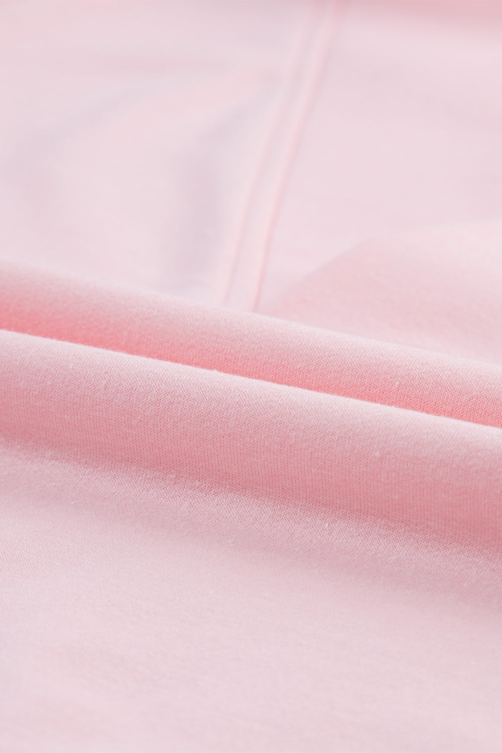 Blush pink V-neck tee with puff sleeves, close-up of soft fabric texture.