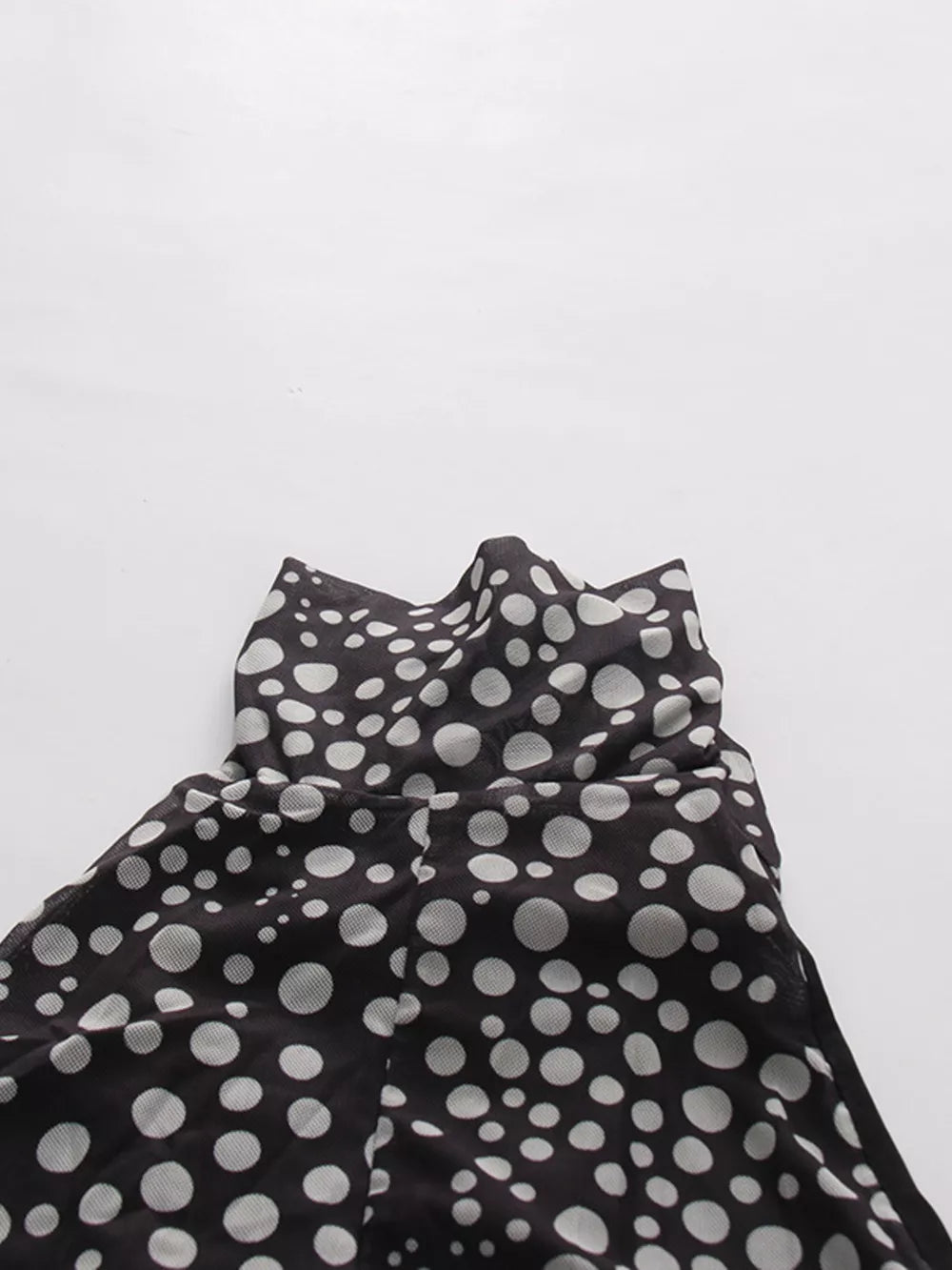 Chic polka dot halter maxi dress with a sheer overlay and ruched detail.