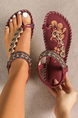 Deep red embellished thong sandals with floral detail and beaded ankle strap