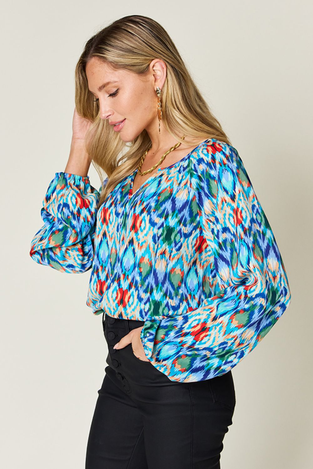 Prismatic ikat blouse in blue with voluminous sleeves and a v-neckline.