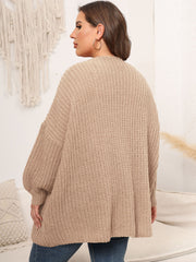 Chunky knit tan cardigan with balloon sleeves and open front, shown from the back.