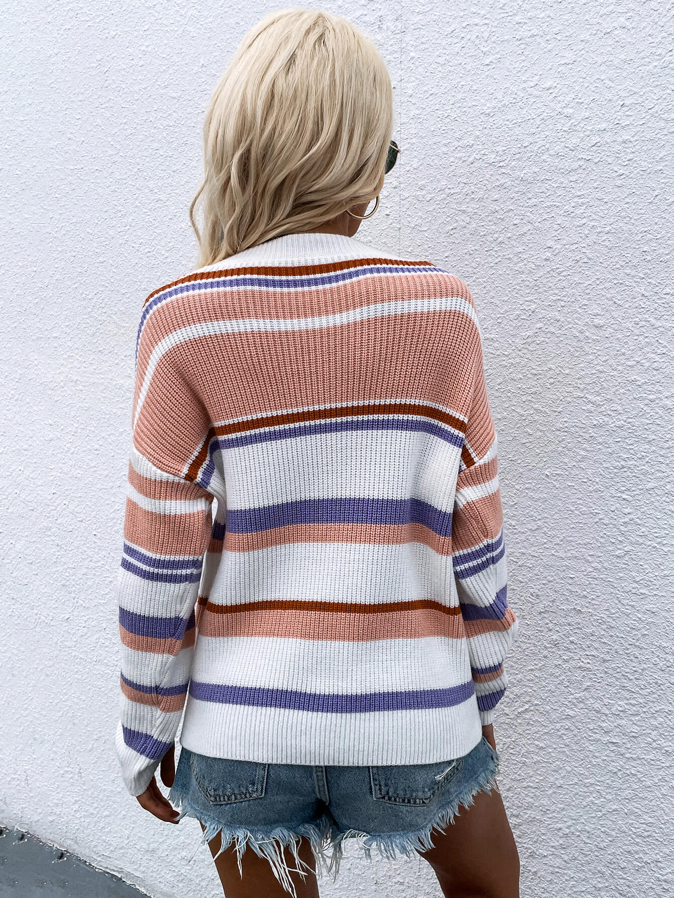 Pastel stripe crewneck knit sweater with peach, purple, and brown stripes on a white background.