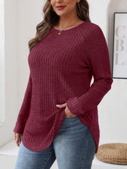Burgundy ribbed knit sweater with raglan sleeves and asymmetric hem detail.