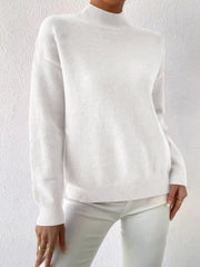 White mock neck knit sweater with dropped shoulders and ribbed cuffs and hem.