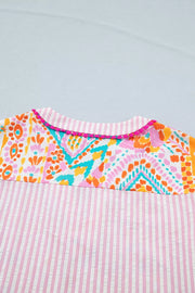 Vibrant patchwork ruffle detail blouse with pink stripes and pom trim.