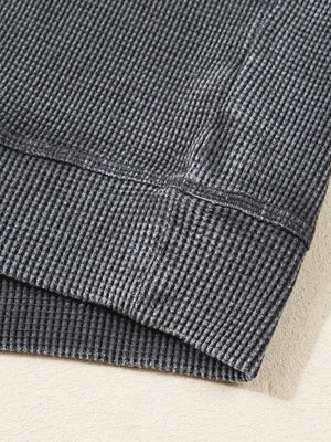 Dark gray waffle knit sweatshirt showing texture and seam detail.