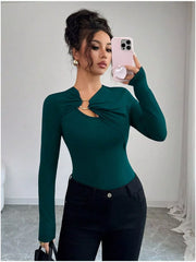 Teal long-sleeve tee with asymmetrical cutout and gold ring detail.