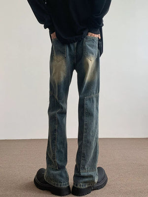 Men's blue vintage wash flare jeans with distressed detailing and paneling.