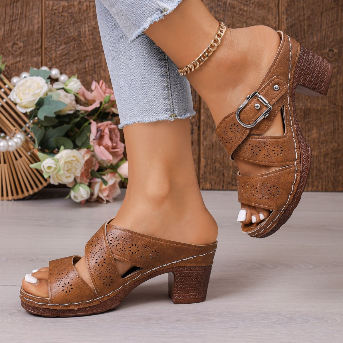 Brown laser-cut criss-cross block heel sandals with buckle detail.