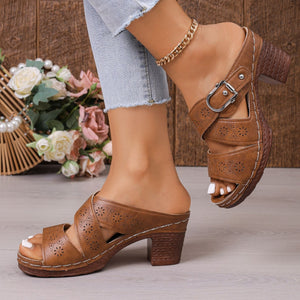 Brown laser-cut criss-cross block heel sandals with buckle detail.