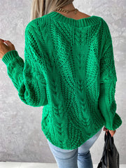 Green cable knit sweater with V-neck and relaxed fit, featuring intricate stitching details.