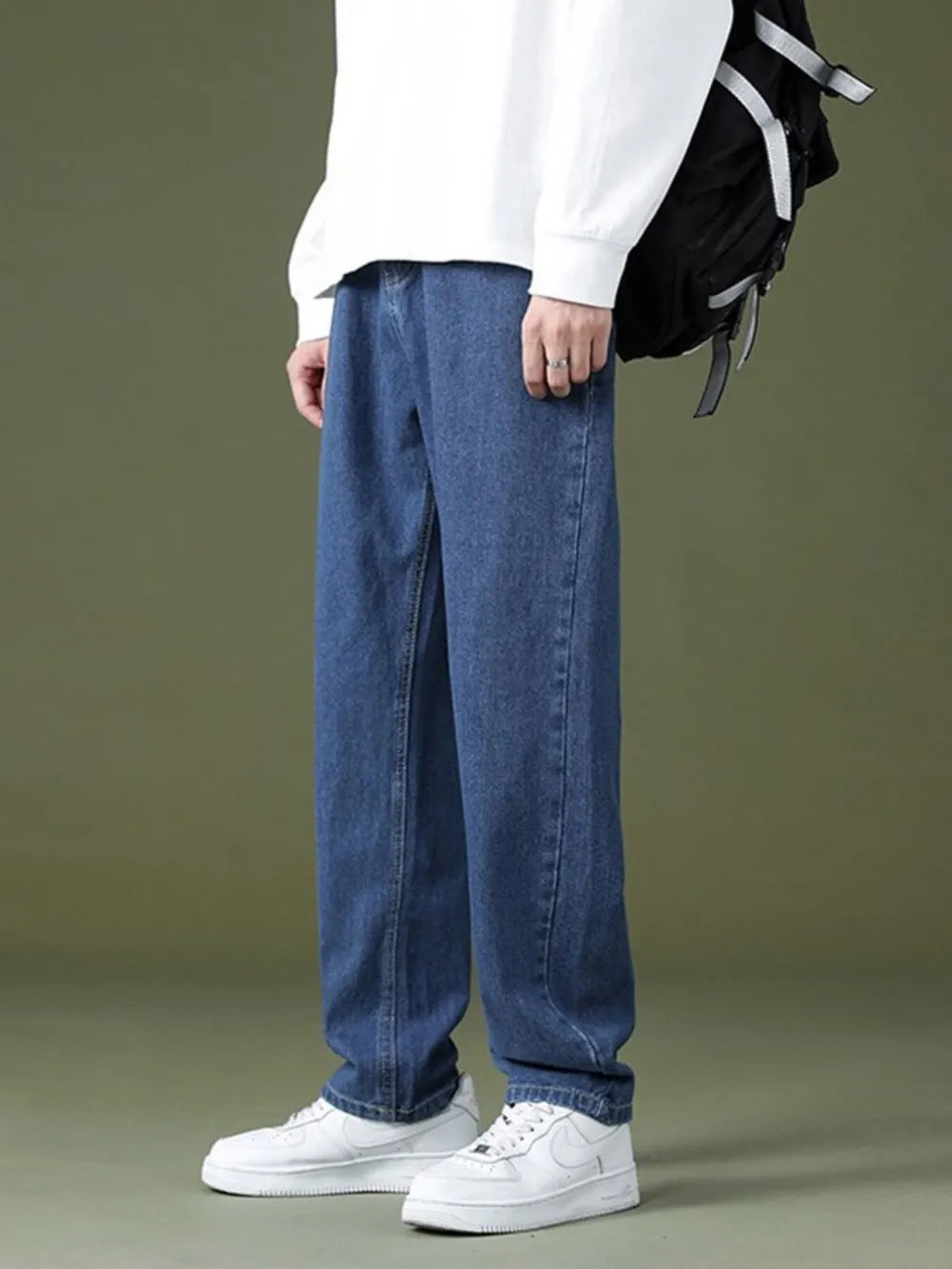 Casual oversized men's dark wash denim jeans with pockets, relaxed fit.
