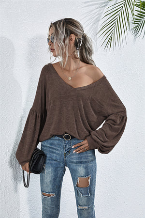 Off-shoulder mocha knit top with blouson sleeves, v-neck, and relaxed fit.