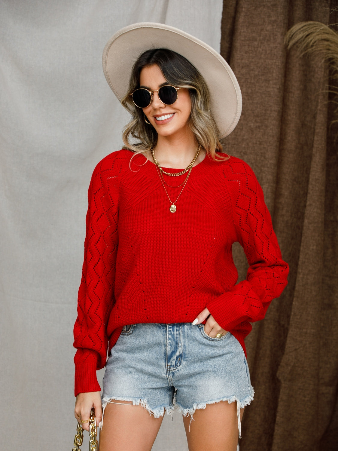 Red diamond-cut raglan knit sweater with crewneck and long sleeves.