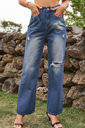 Distressed wide-leg denim trousers in medium blue with ripped details.