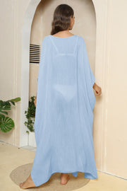 Light blue oversized caftan cover-up with side slits, showing bikini underneath.