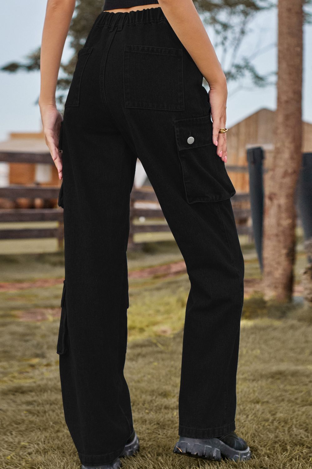 Black denim cargo pants with relaxed wide leg and utility pockets.