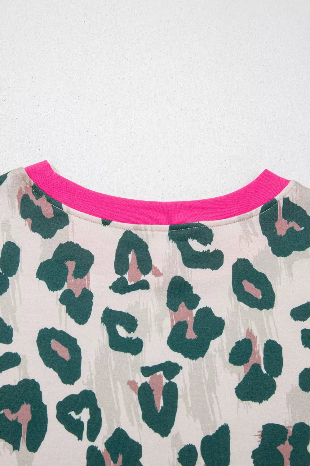 Pajama top with leopard print, crew neck, and pink trim detail.