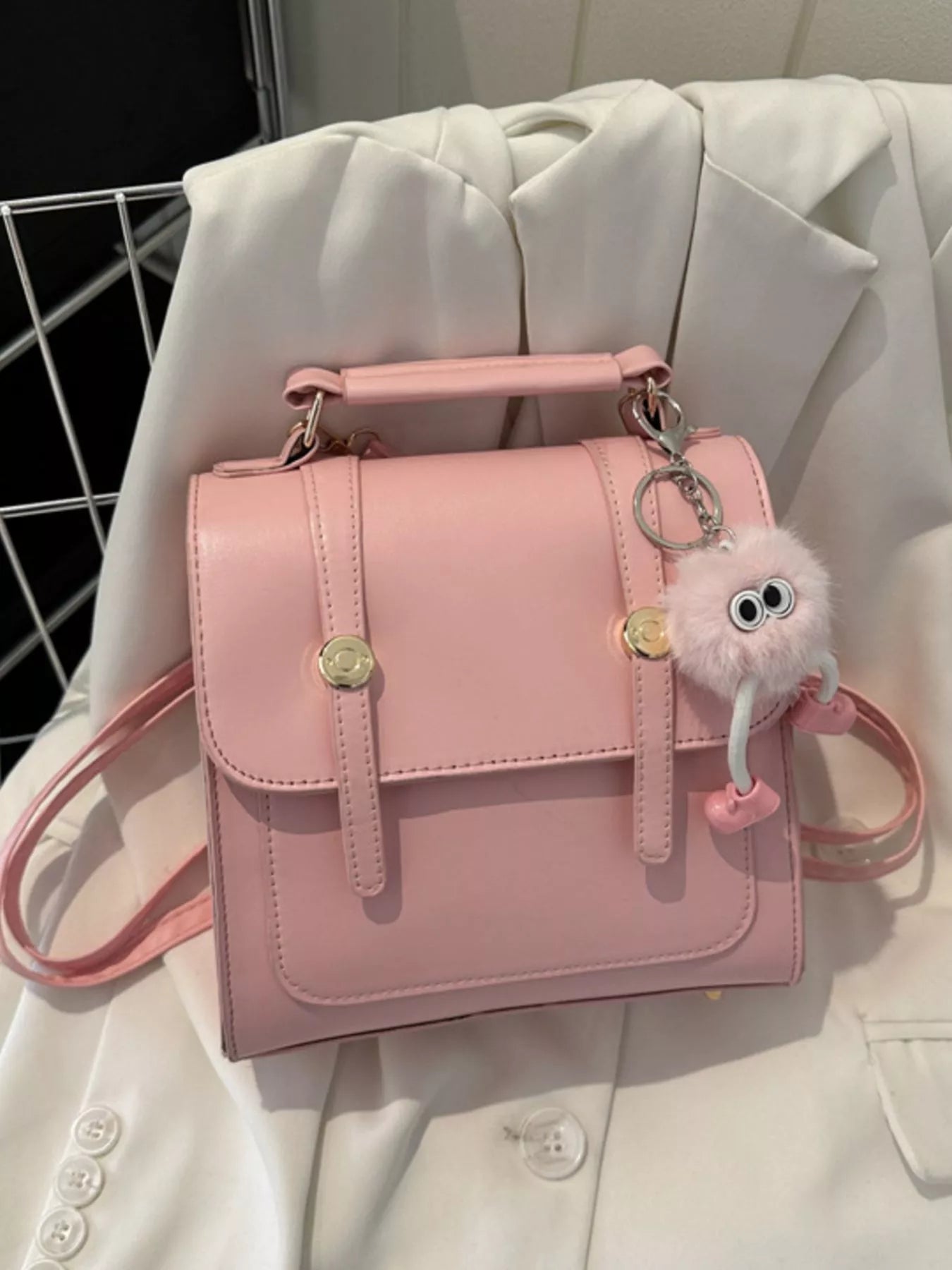 Chic pink PU leather mini backpack with cute fuzzy charm and gold hardware.