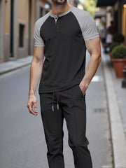 Men's black loungewear set with grey raglan sleeves and drawstring pants.