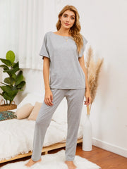 Gray loungewear set with asymmetric neckline and short sleeves, paired with matching pants.