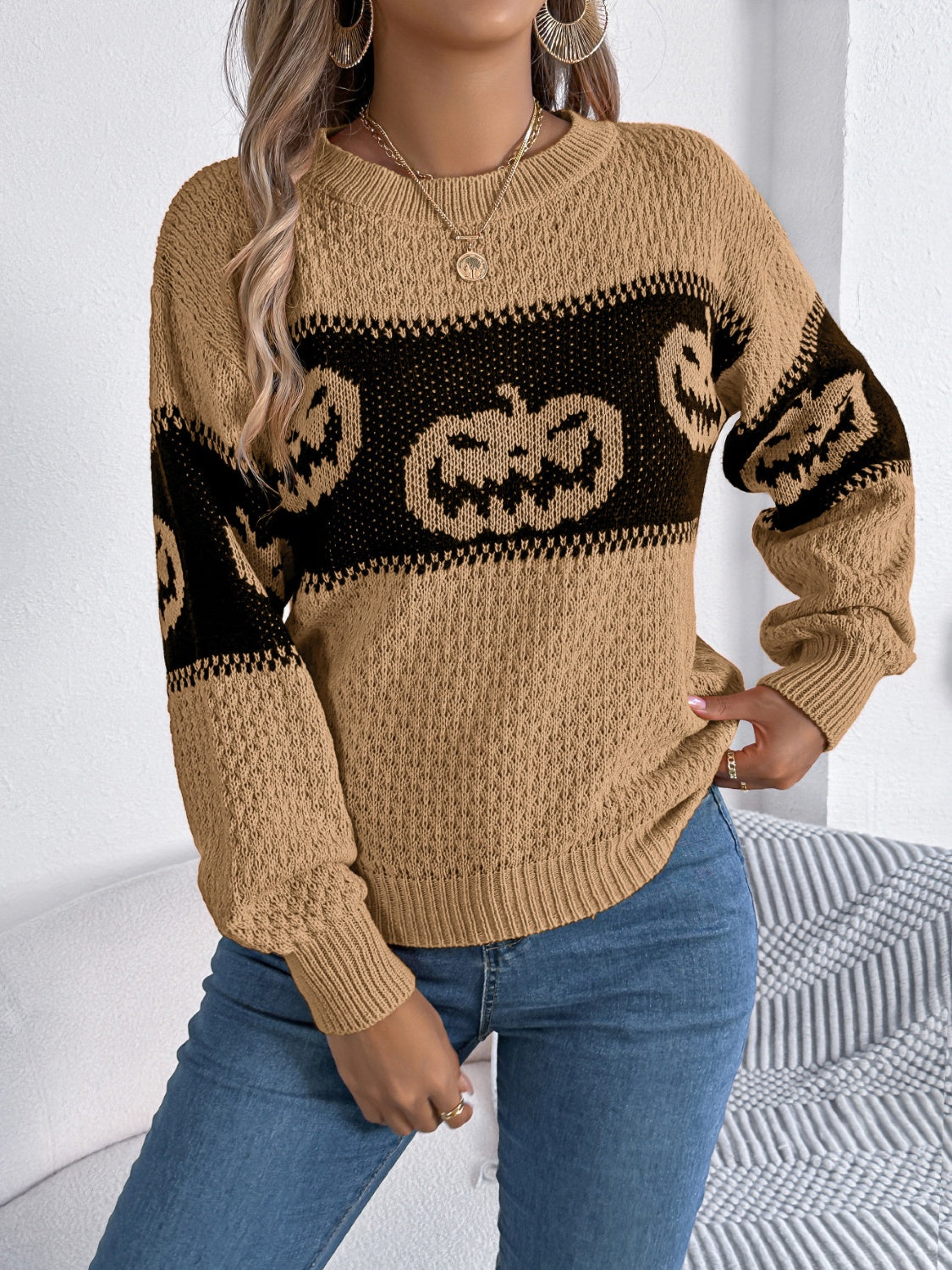 Camel knit sweater with black jack-o'-lantern intarsia pattern and crew neck.