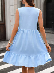 Sky blue sleeveless V-neck dress with ruffle hem and textured fabric.