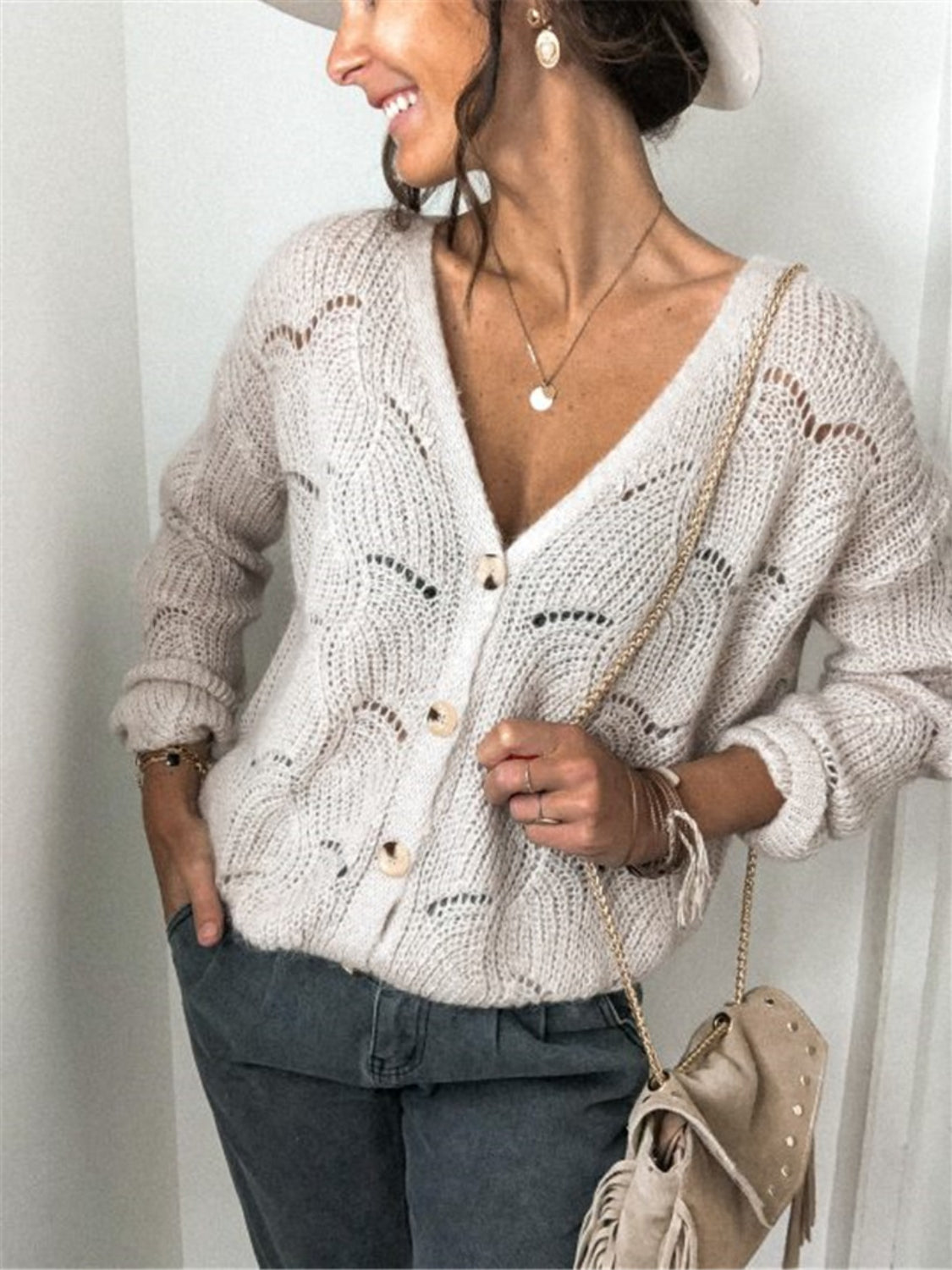 Beige scalloped knit button-down cardigan with openwork details and wooden buttons.