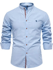 Light blue linen shirt with mandarin collar, button front, and embroidered detail.