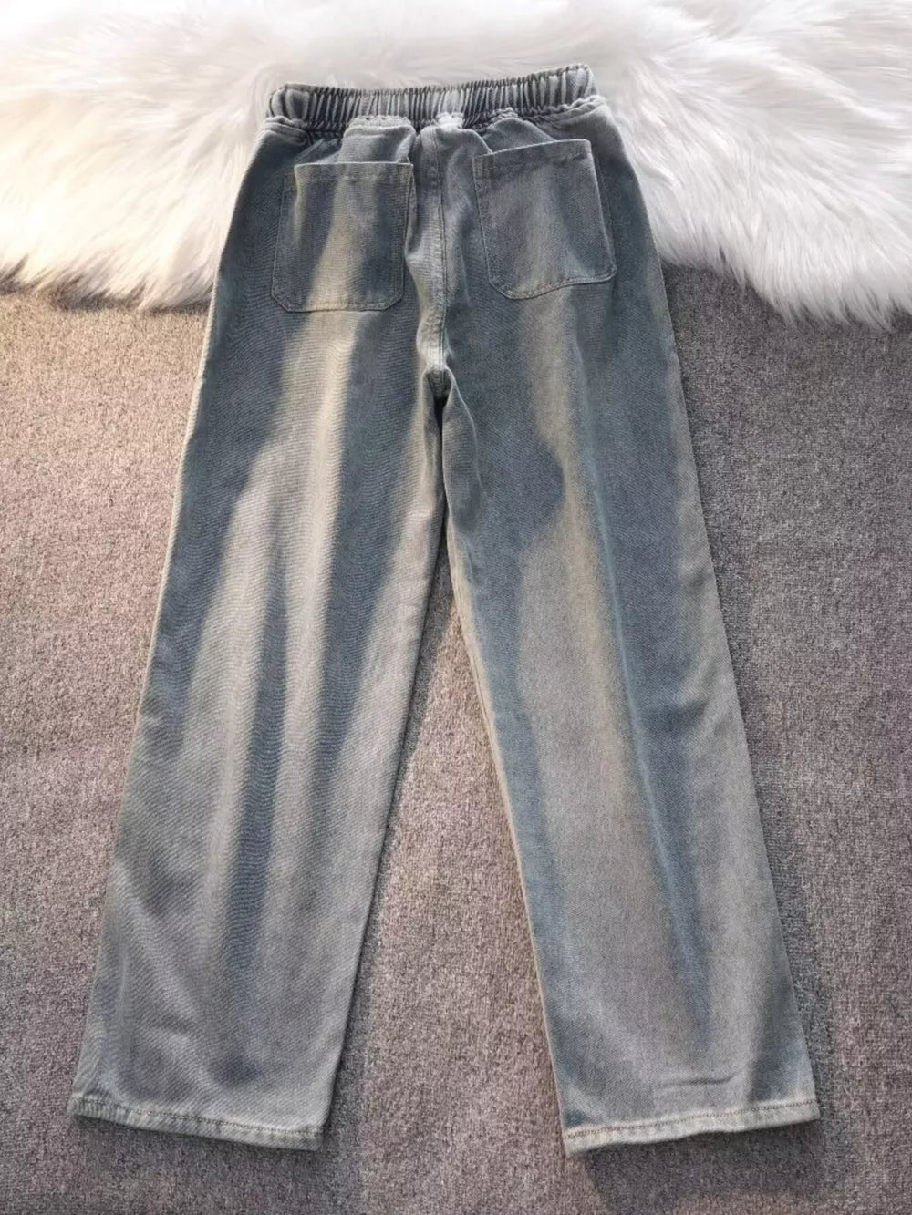 Blue vintage wash wide-leg jeans with drawstring waist and back pockets.
