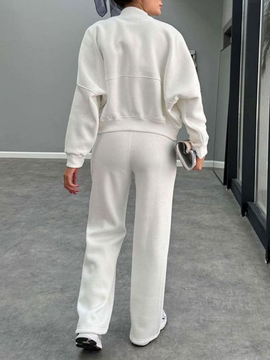 White bomber jacket and wide-leg tracksuit with crew neck and ribbed cuffs.