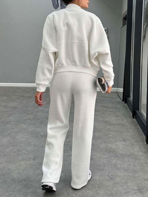White bomber jacket and wide-leg tracksuit with crew neck and ribbed cuffs.