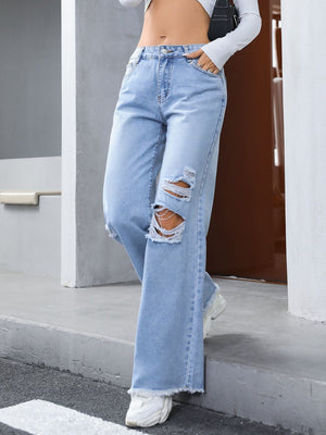Light wash distressed wide-leg jeans with fray hem and ripped knees.