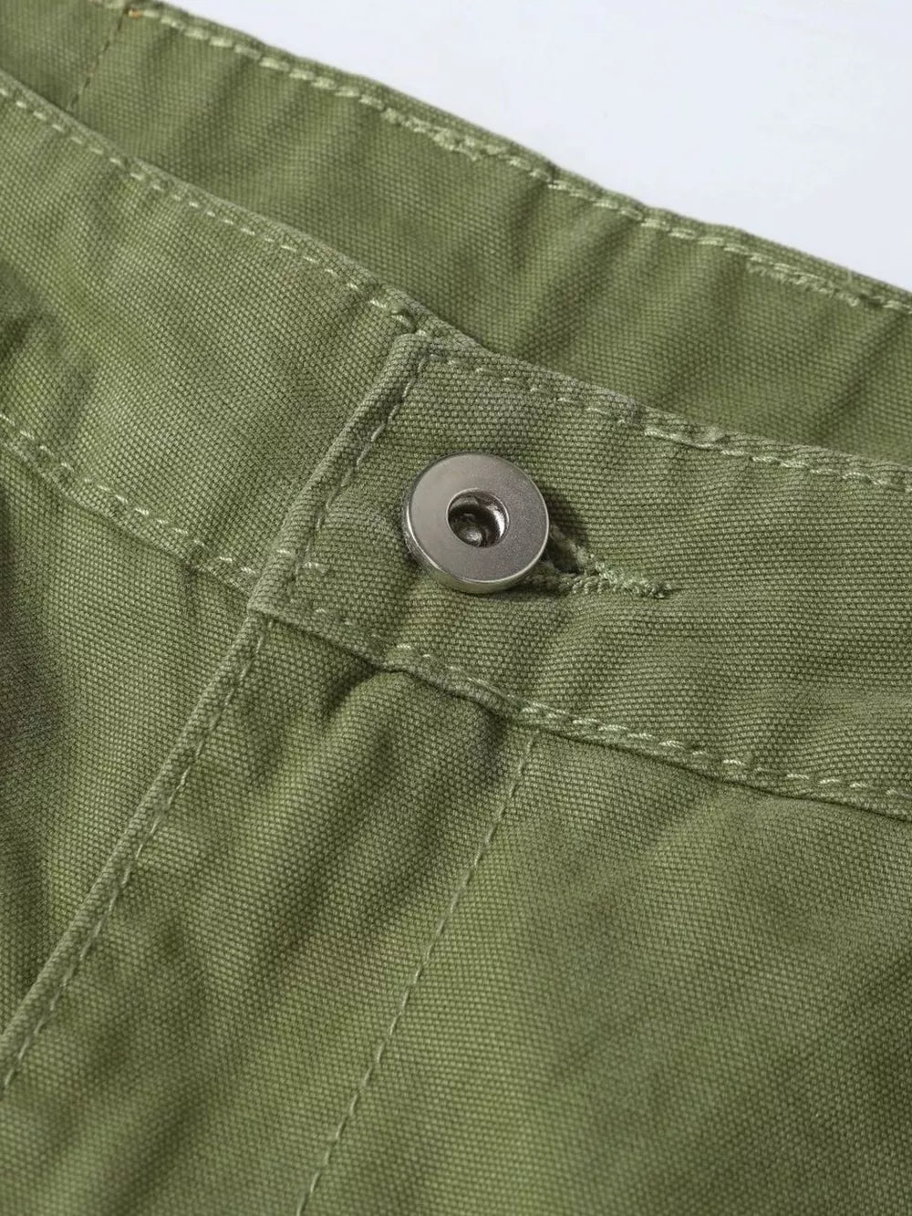 Green cargo pants with button closure and visible stitching detail