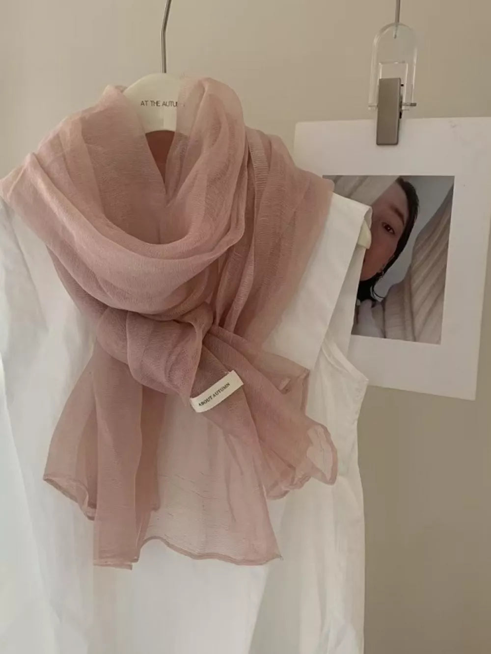 Delicate sheer polyester scarf in Quicksand Powder, tied and draped over a white garment.
