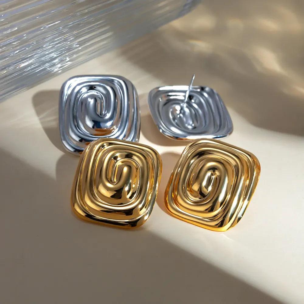 Sculpted swirl square earrings in gold and silver with a contemporary design.