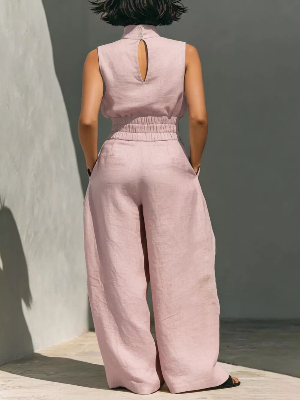 Pink sleeveless turtleneck top with keyhole back and wide-leg pants set.