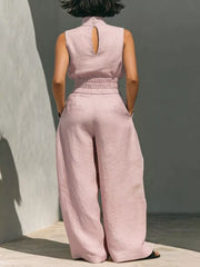Pink sleeveless turtleneck top with keyhole back and wide-leg pants set.