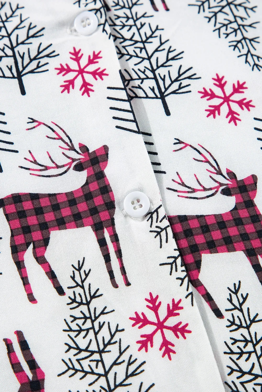 White pajama set with festive reindeer, snowflake, and tree print.