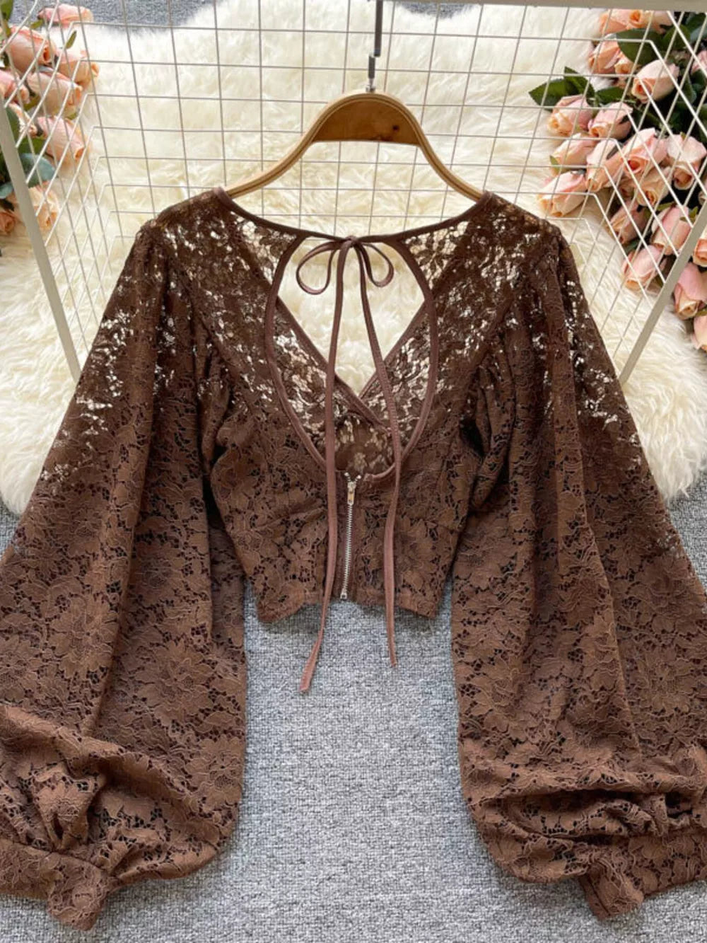 Brown sheer floral lace cropped shirt with balloon sleeves and back tie detail.
