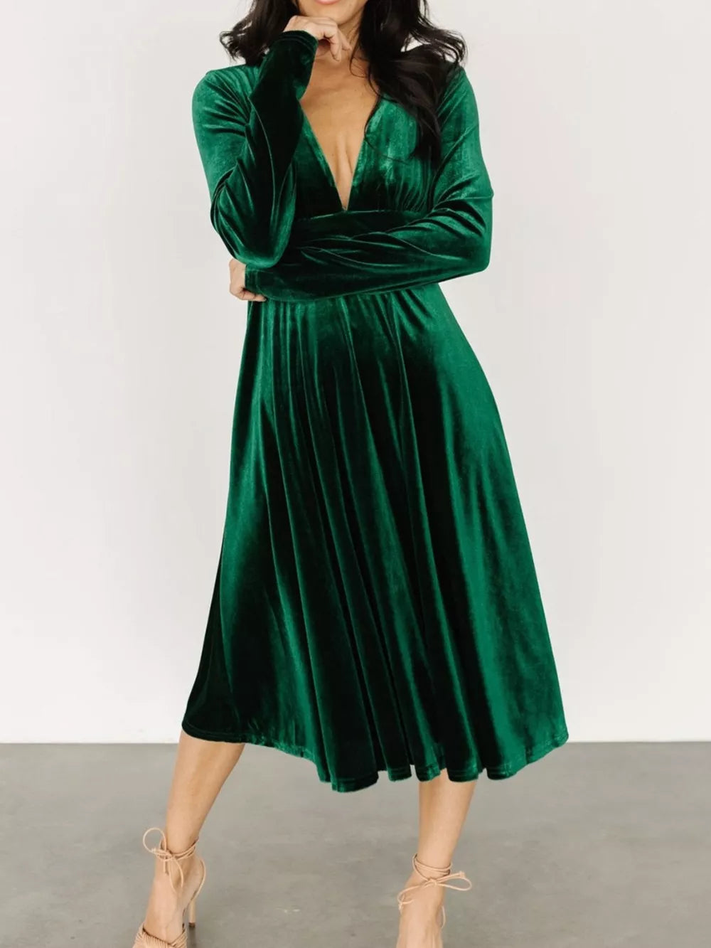 Dark green velvet midi dress with plunging V-neck and long sleeves.