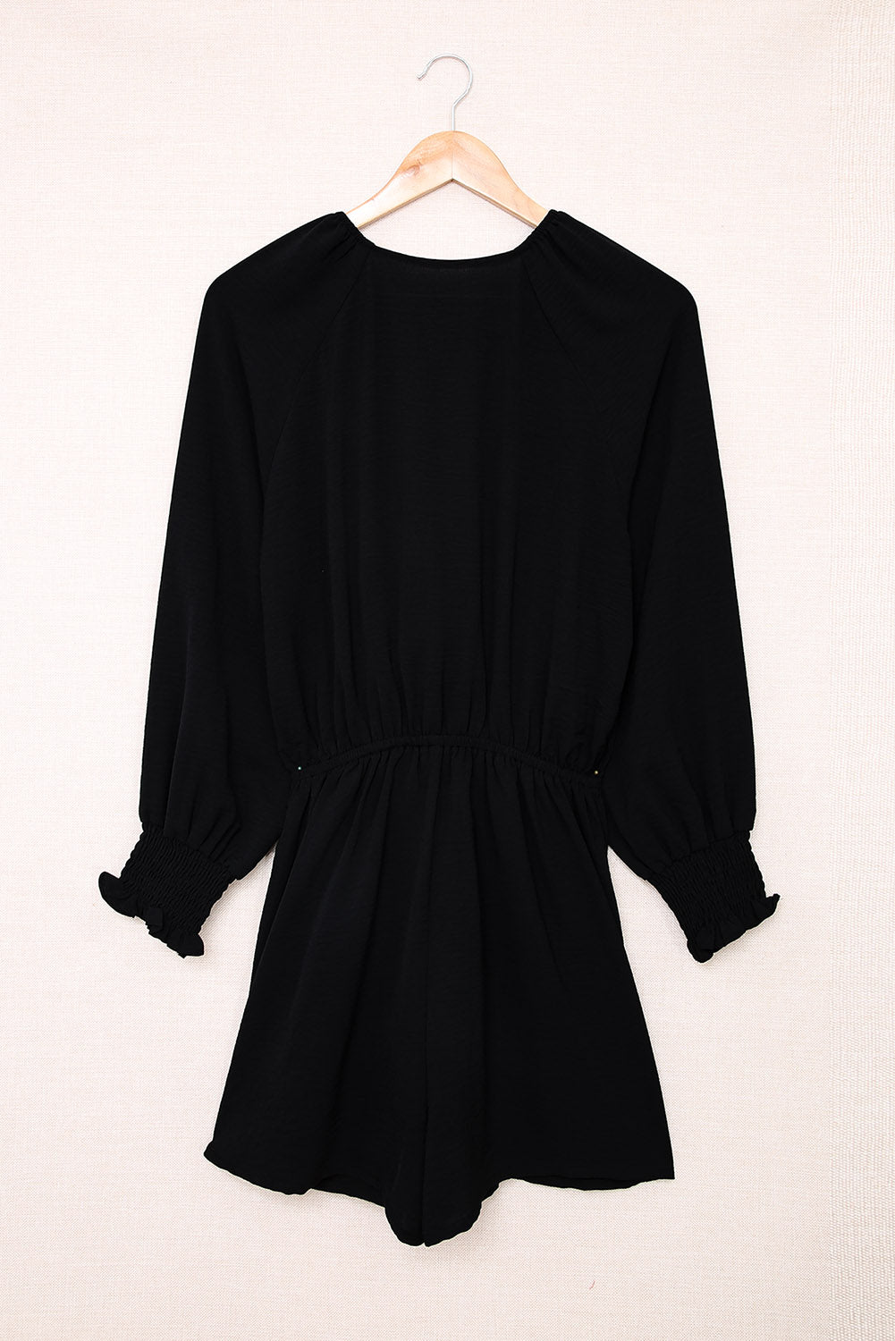 Black tie-front blouson sleeve playsuit with smocked cuffs and waist.