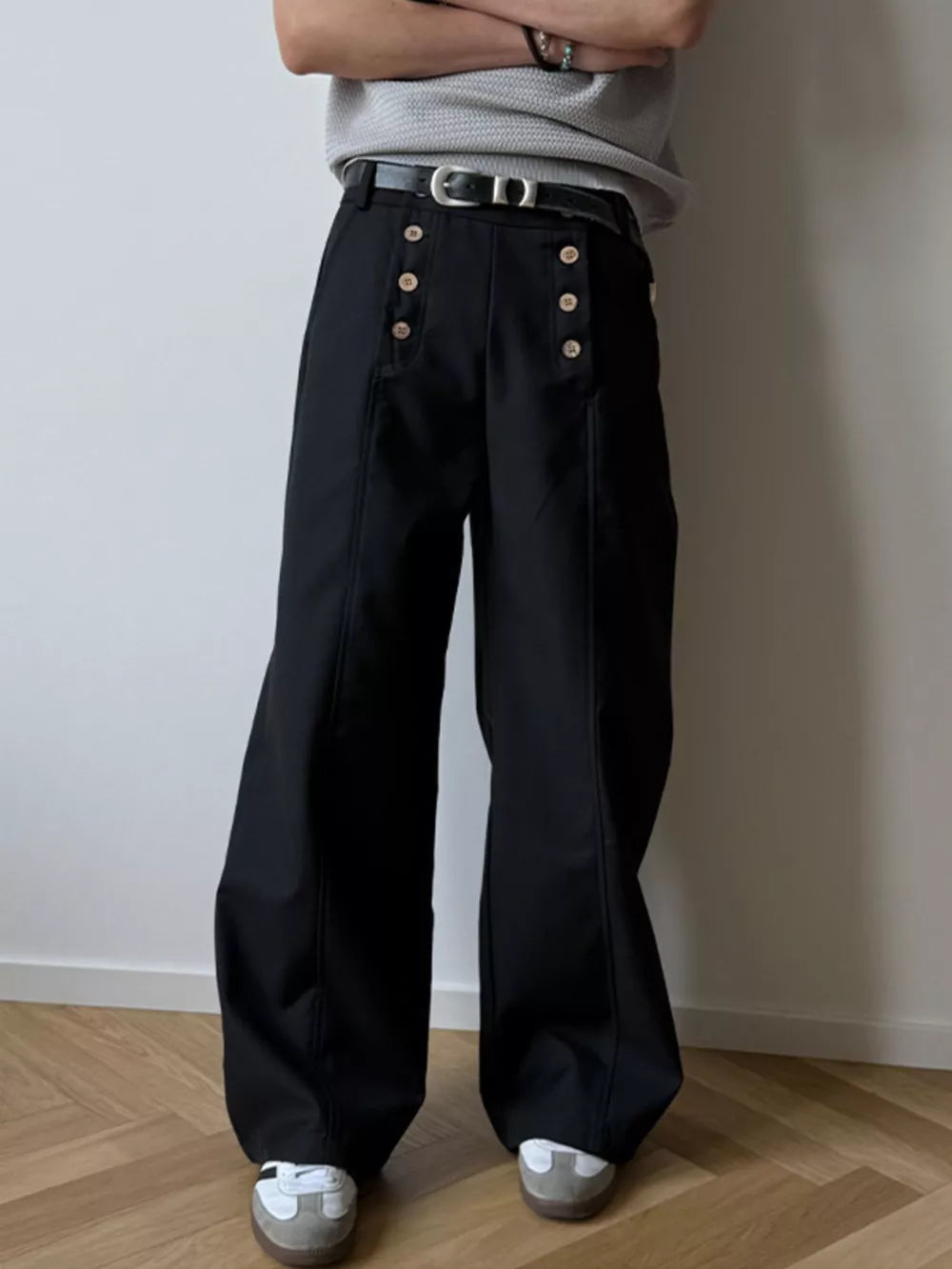 Black high-waisted wide leg pants with button detail and a belt.