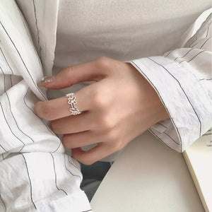 Sterling silver open ring with delicate floral motif, a dainty accessory for women.